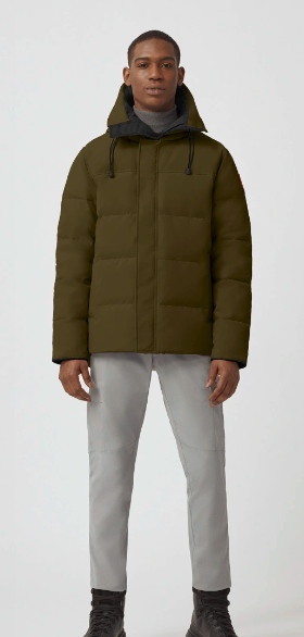 A man wearing an olive Canada Goose down jacket and grey pants