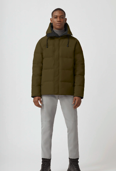 A man wearing an olive Canada Goose down jacket and grey pants