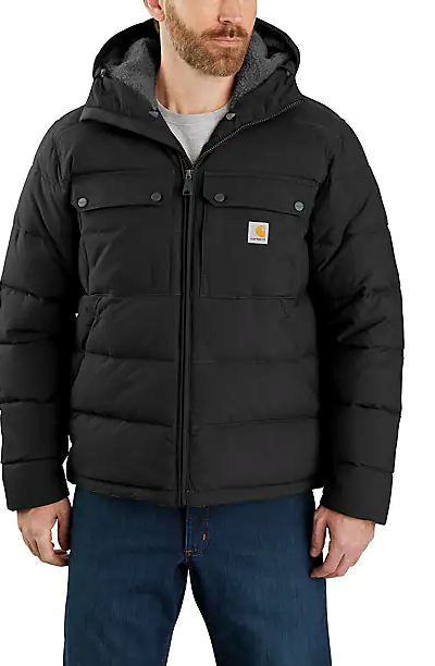 A man wearing a heavy-duty Carhartt black jacket and blue jeans