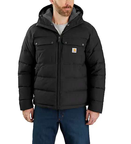A man wearing a heavy-duty Carhartt black jacket and blue jeans
