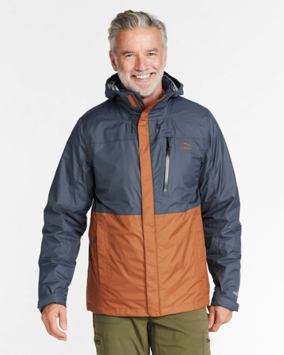 A man wearing a brown and navy blue LL Bean winter jacket and olive green pants