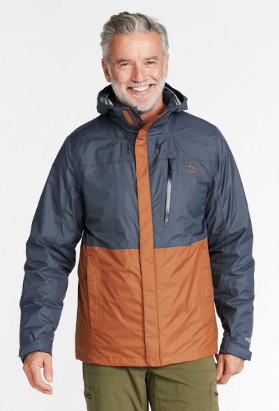 A man wearing a brown and navy blue LL Bean winter jacket and olive green pants