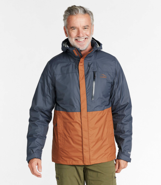 A man wearing a brown and navy blue LL Bean winter jacket and olive green pants