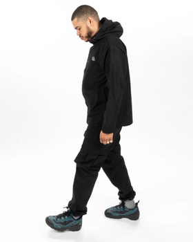 A man wearing an all-black Poler outfit feating a winter jacket and pants
