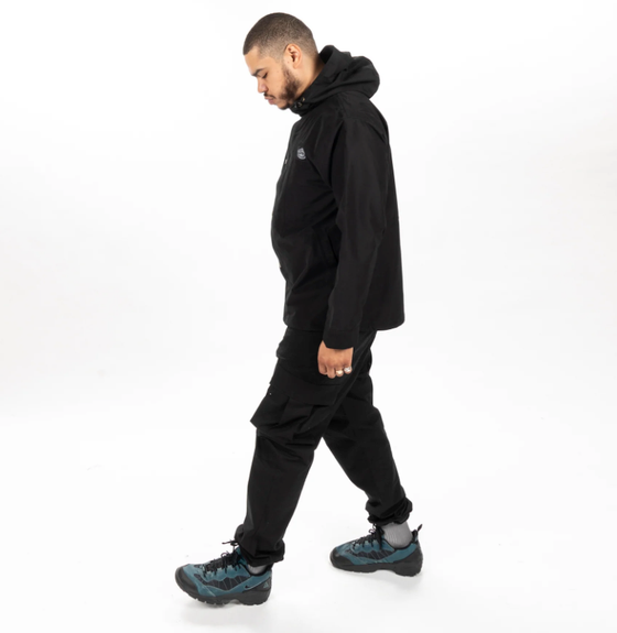 A man wearing an all-black Poler outfit feating a winter jacket and pants