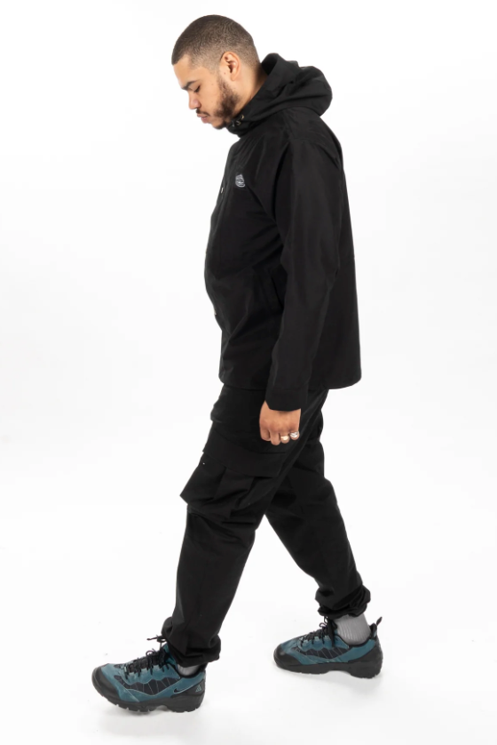 A man wearing an all-black Poler outfit feating a winter jacket and pants
