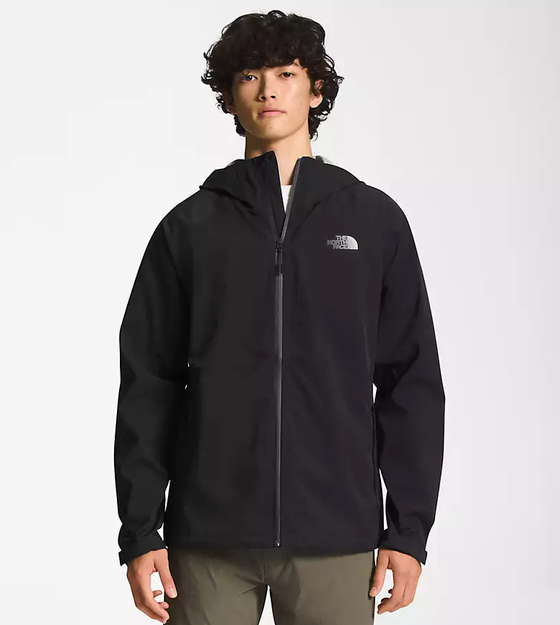 A man wearing a black North Face winter jacket and green pants