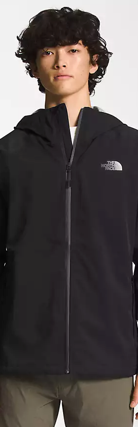 A man wearing a black North Face winter jacket and green pants