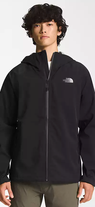 A man wearing a black North Face winter jacket and green pants
