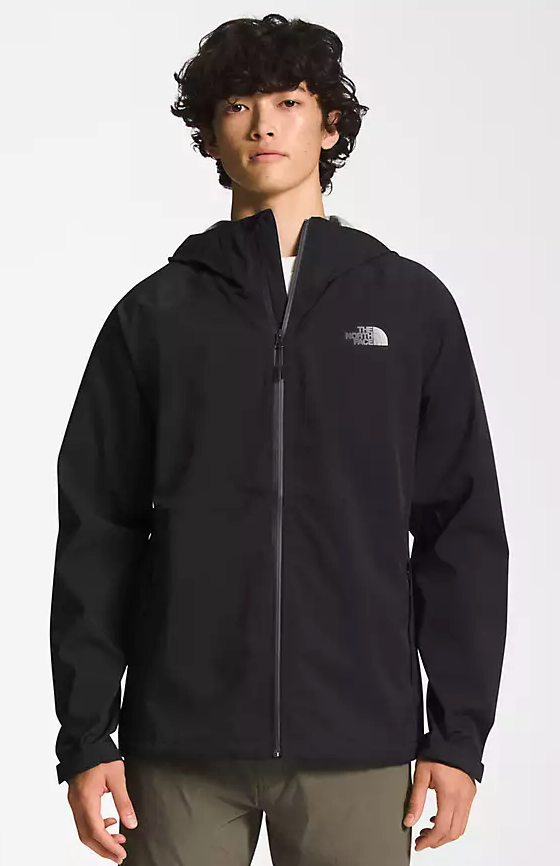 A man wearing a black North Face winter jacket and green pants
