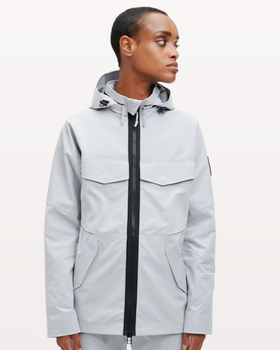A woman wearing a light grey futuristic, contemporary On-Running Jacket