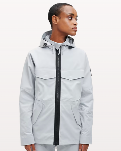 A woman wearing a light grey futuristic, contemporary On-Running Jacket
