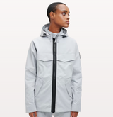 A woman wearing a light grey futuristic, contemporary On-Running Jacket