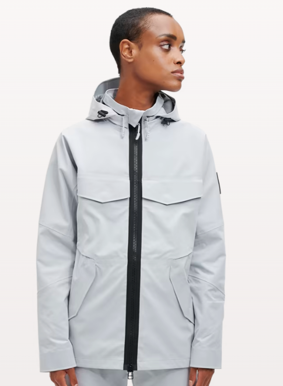 A woman wearing a light grey futuristic, contemporary On-Running Jacket