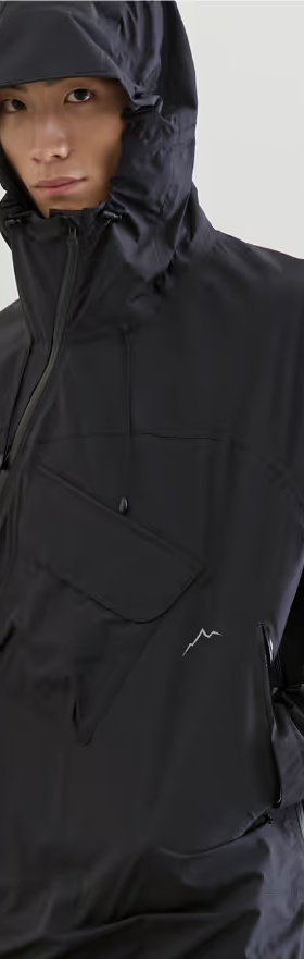 A man wearing a black CAYL jacket with his hood on