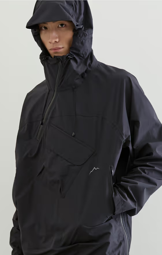 A man wearing a black CAYL jacket with his hood on