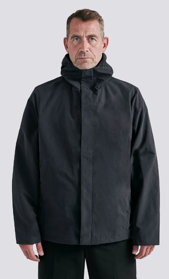 A man wearing a black Arys winter jacket and black pants