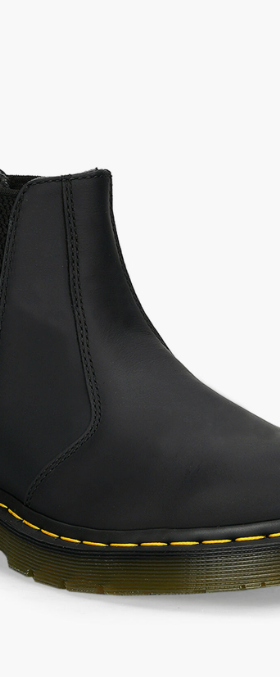 A black pair of slip-on Dr. Martens boots on a white background