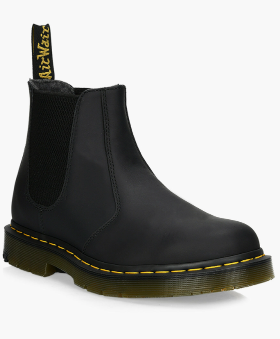 A black pair of slip-on Dr. Martens boots on a white background
