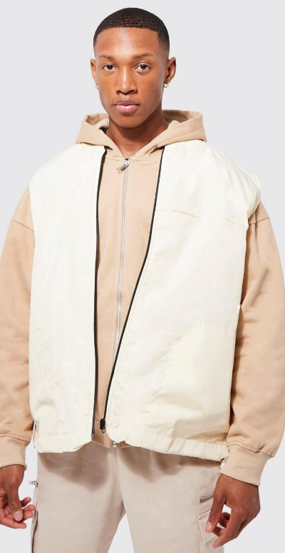 A man wearing a Boohooman cream vest and beige sweatshirt