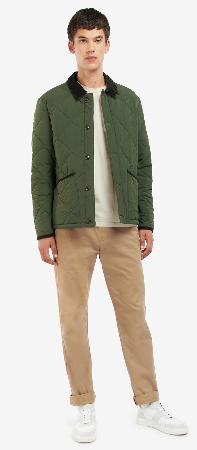 A man wearing a Barbour green jacket, a cream t-shirt and brown pants