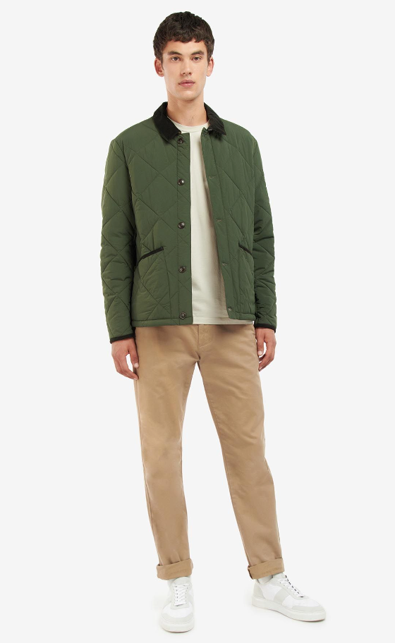A man wearing a Barbour green jacket, a cream t-shirt and brown pants