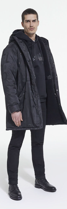 A man wearing The Kooples black jacket, with a black hoodie, pants and boots