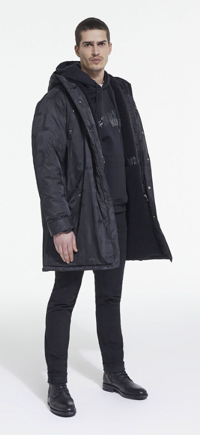 A man wearing The Kooples black jacket, with a black hoodie, pants and boots