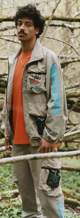 A man in the woods wearing an Adidas Palace collab outfit