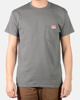 A man wearing a dark grey Ben Davis pocket t-shirt and brown pants