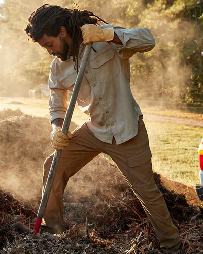 A man wearing a Duluth Trading outfit while shoveling outside