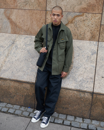 A man wearing a Stan Ray workwear button up and navy blue pants