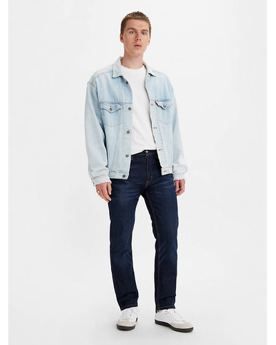 A man wearing a denim Levis jacket, white t-shirt and black pants