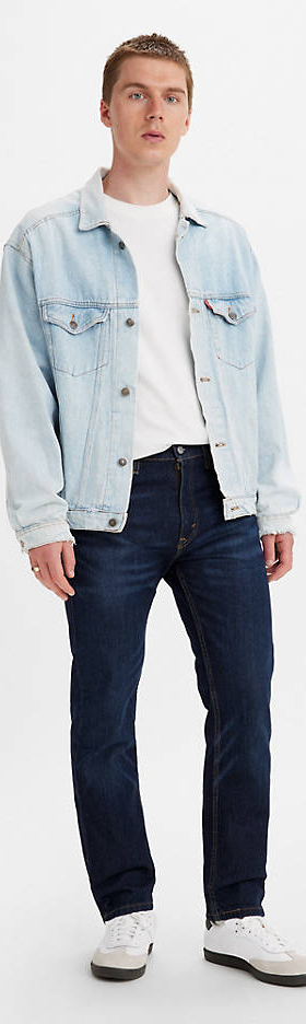 A man wearing a denim Levis jacket, white t-shirt and black pants