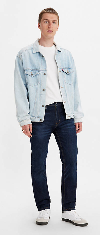 A man wearing a denim Levis jacket, white t-shirt and black pants