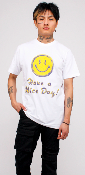 A man wearing a white smiley face Chinatown Market t-shirt and black pants