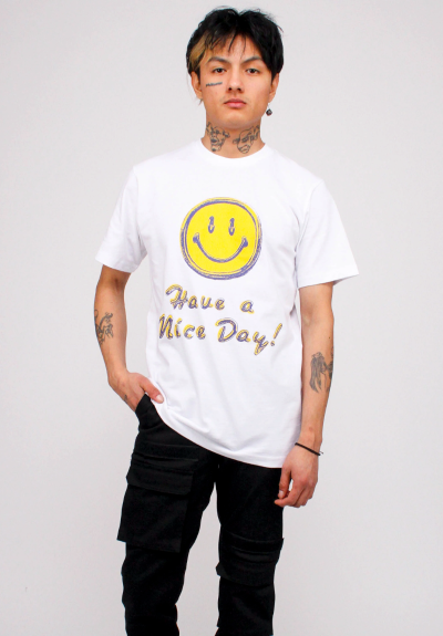 A man wearing a white smiley face Chinatown Market t-shirt and black pants