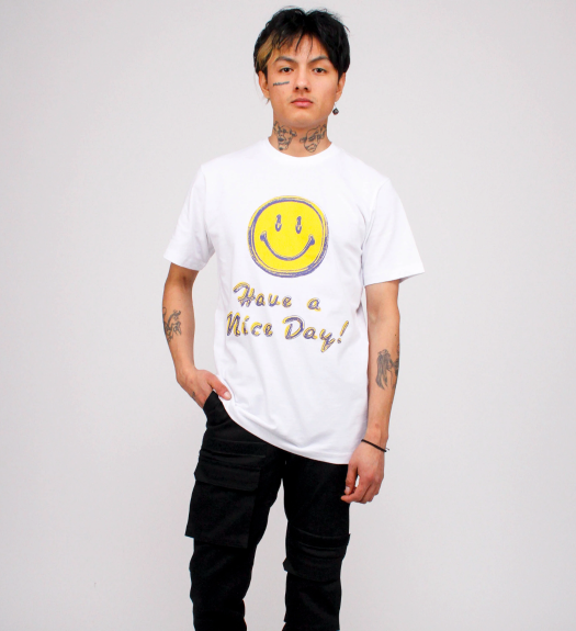 A man wearing a white smiley face Chinatown Market t-shirt and black pants