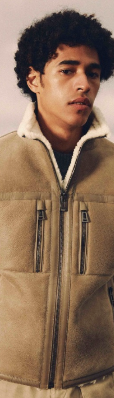 A man wearing a Belstaff sheepskin jacket with khaki pants