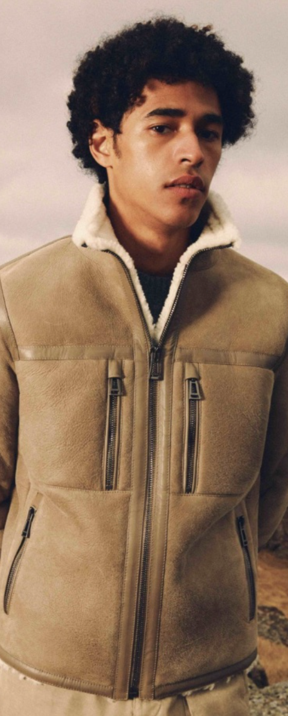 A man wearing a Belstaff sheepskin jacket with khaki pants