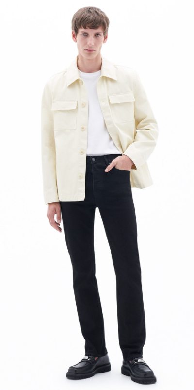A man wearing a cream Filippa K overshirt, a white t-shirt and black slacks