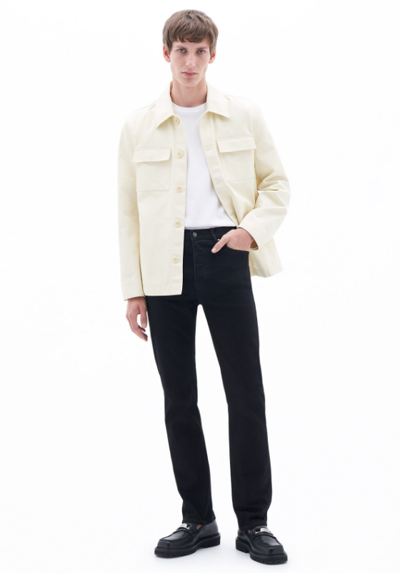 A man wearing a cream Filippa K overshirt, a white t-shirt and black slacks