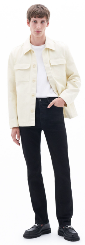 A man wearing a cream Filippa K overshirt, a white t-shirt and black slacks