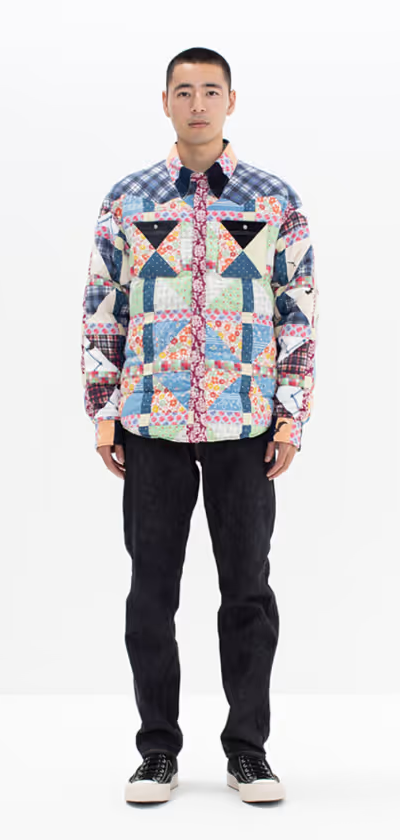 A man wearing a colorful Vivsim button up with black pants and black sneakers