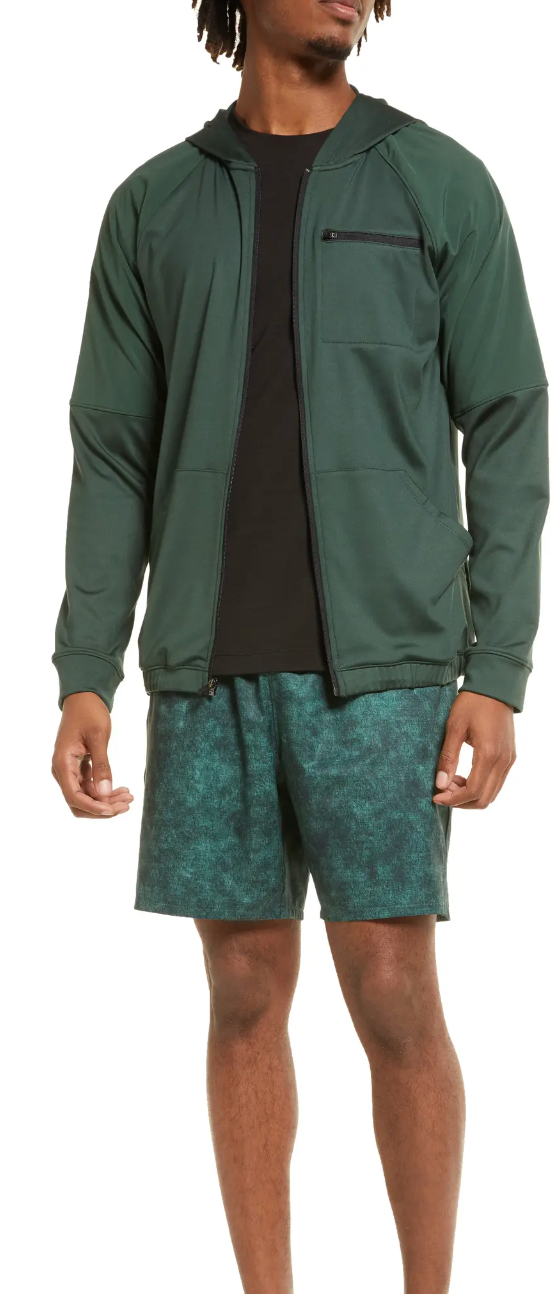 A man standing in a green Zella by Nordstrom jacket and shorts