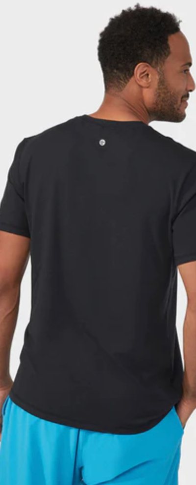 A man wearing a Manduka athletic outfit with a black shirt and bright blue pants