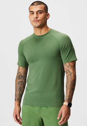 A man wearing a tight-fitting green Fabletics athletic shirt and pants