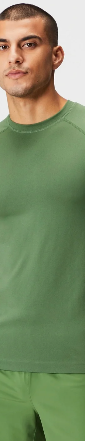 A man wearing a tight-fitting green Fabletics athletic shirt and pants