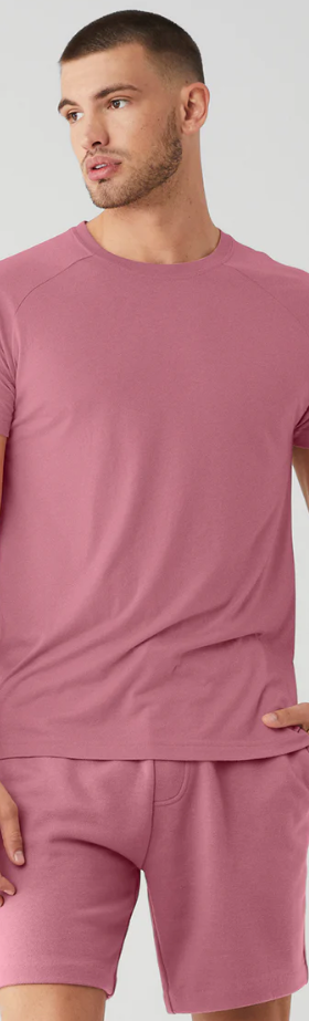 A man wearing a red Alo Yoga t-shirt and matching yoga shorts