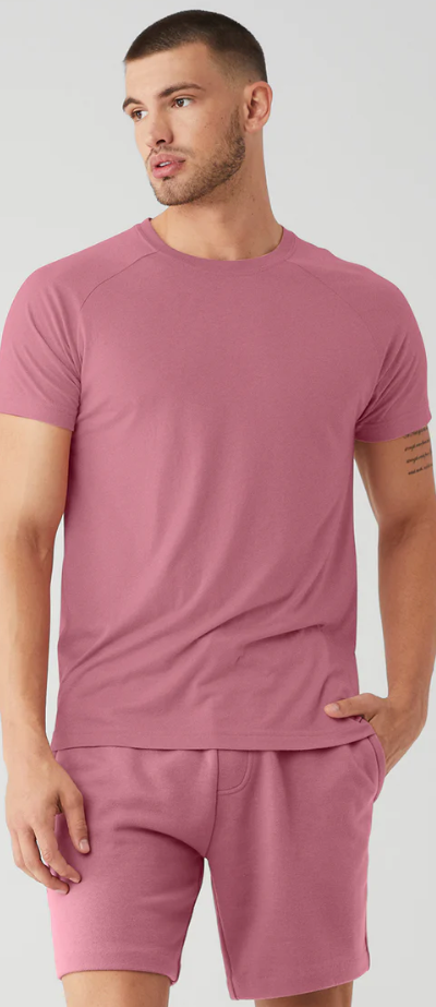 A man wearing a red Alo Yoga t-shirt and matching yoga shorts
